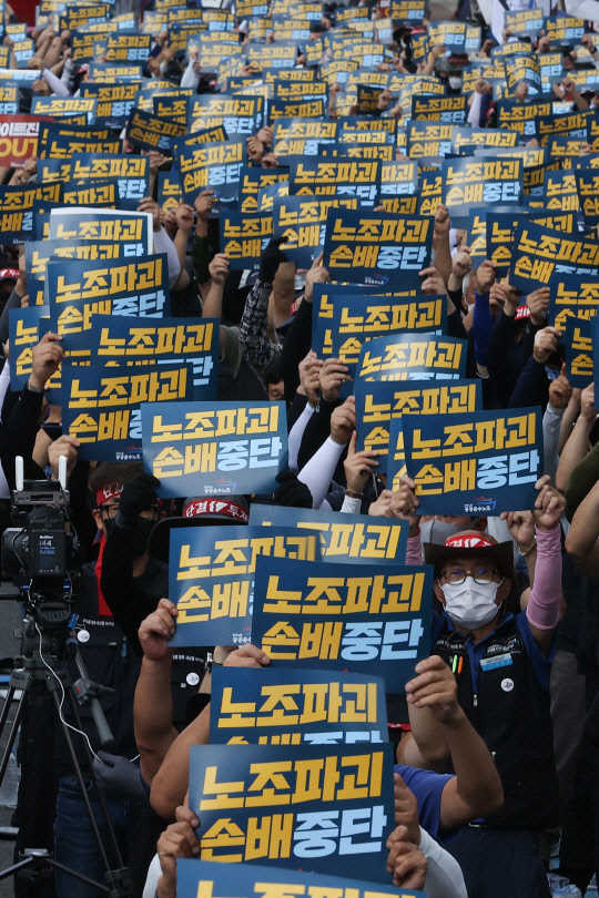 지난 18일 민주노총 공공운수노조 조합원들이 서울 청담동 하이트진로 본사 앞에서 화물연대 고공농성투쟁 승리 결의대회를 열고 구호를 외치고 있다. 연합뉴스